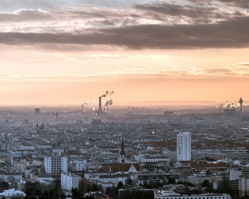 Vienna's Danube City skyline reflected in still water at sunset, the Donauturm on the right