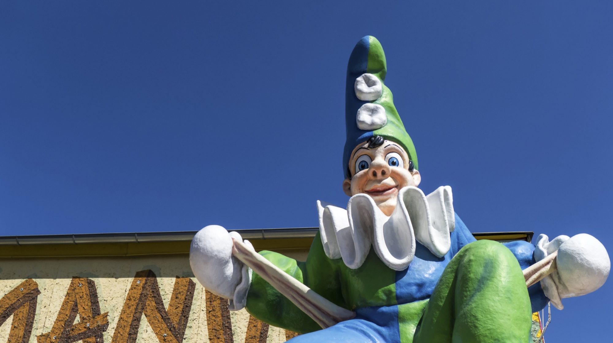 The brightly painted Calafati figure at the Wurstelprater funfair against a blue sky