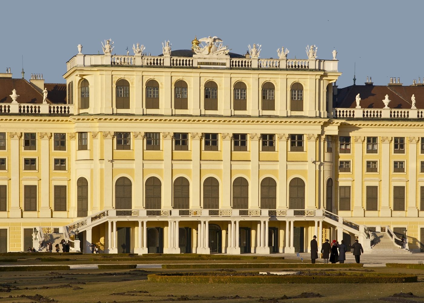 The yellow garden facade of Schönbrunn Palace in late afternoon light, seen across the parterre