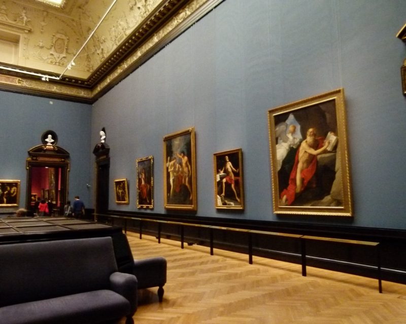 A picture gallery at the Kunsthistorisches Museum, old master paintings hung on deep blue walls