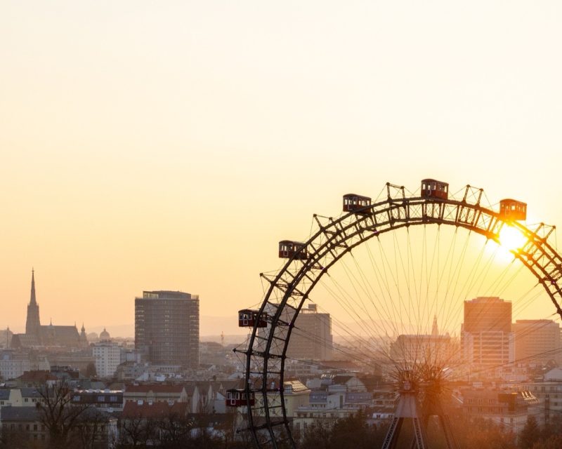 The Wiener Riesenrad silhouetted against a low sun over the Vienna skyline