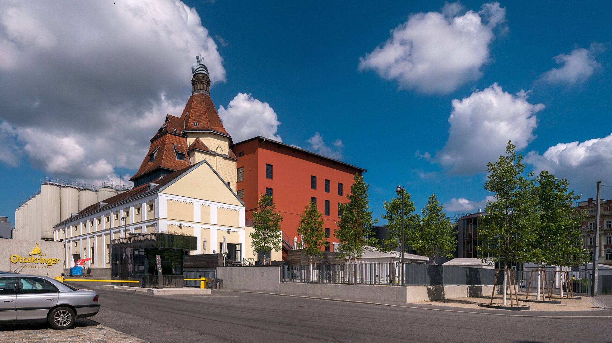 The Ottakringer brewery in Vienna: its turreted brewhouse, red malt store and steel fermentation tanks under a blue sky